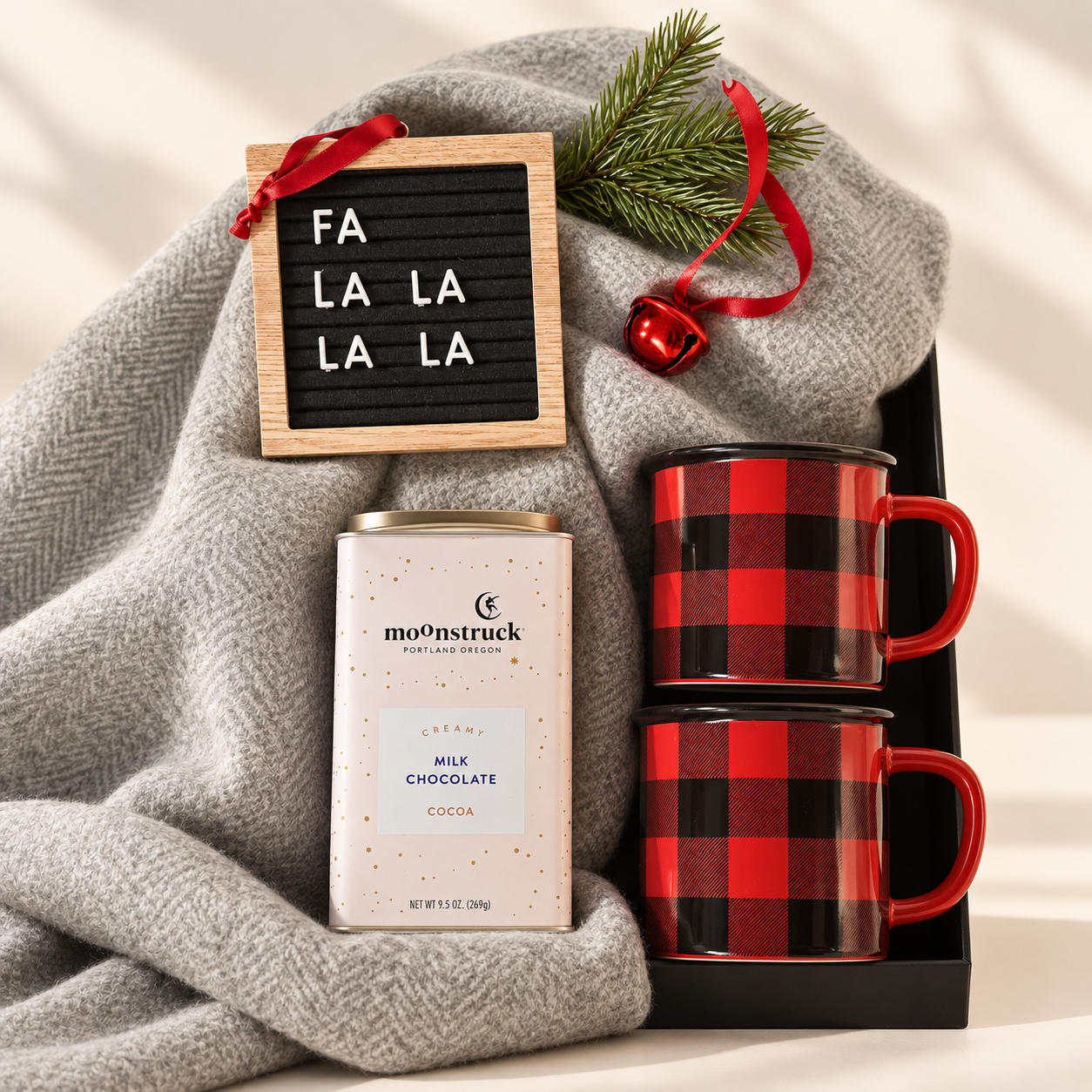 Gift box with herringbone blanket, Moonstruck hot chocolate, buffalo plaid mugs, and ornament