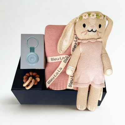 Handmade bunny from cuddle+kind, pink blanket, silicone teething ring, hatch sound machine on a white background