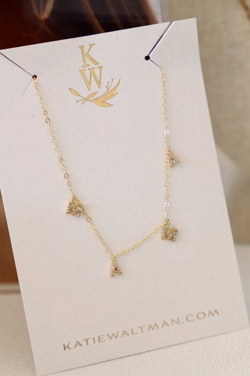 Gold necklace with MAMA letter charms by Katie Waltman