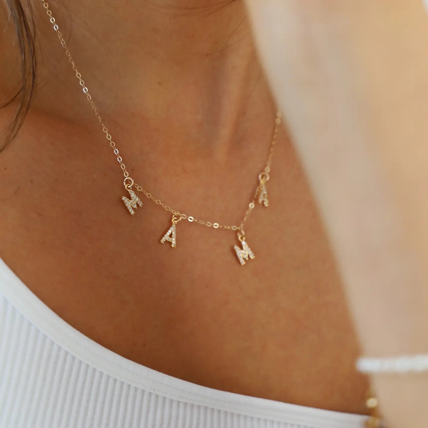 Gold necklace with MAMA letter charms by Katie Waltman