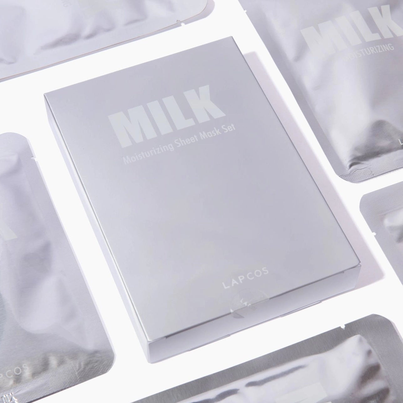 Milk skincare product packaging on a white background by LAPCOS