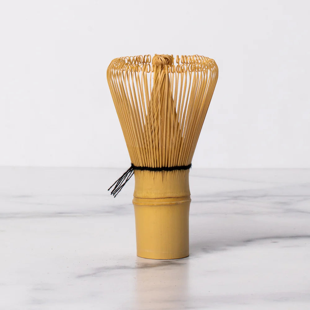 Bamboo whisk on a white marble surface