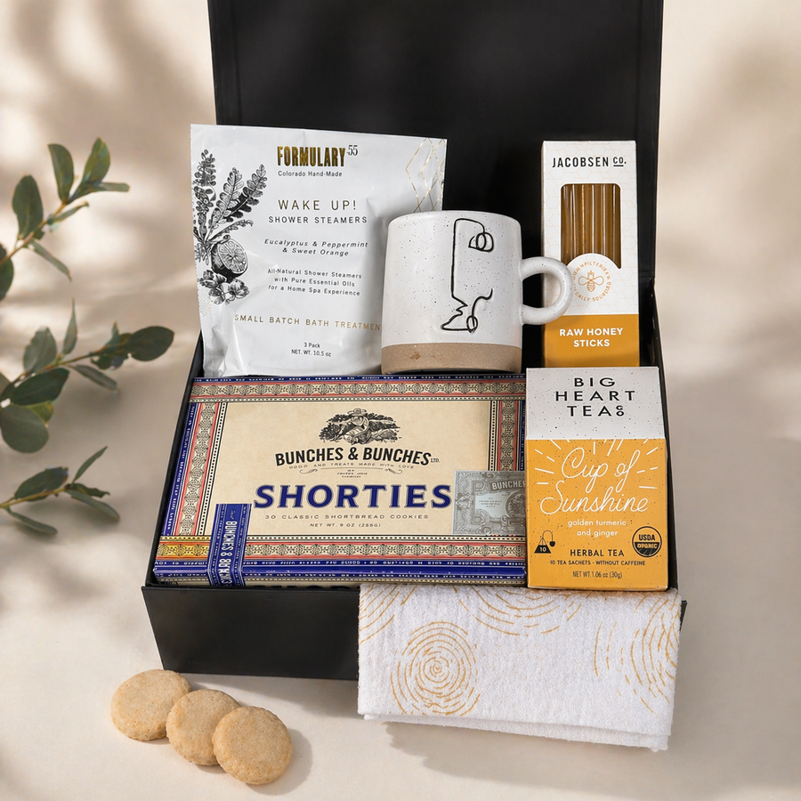 Gift set with tea, cookies, and other items on a neutral background