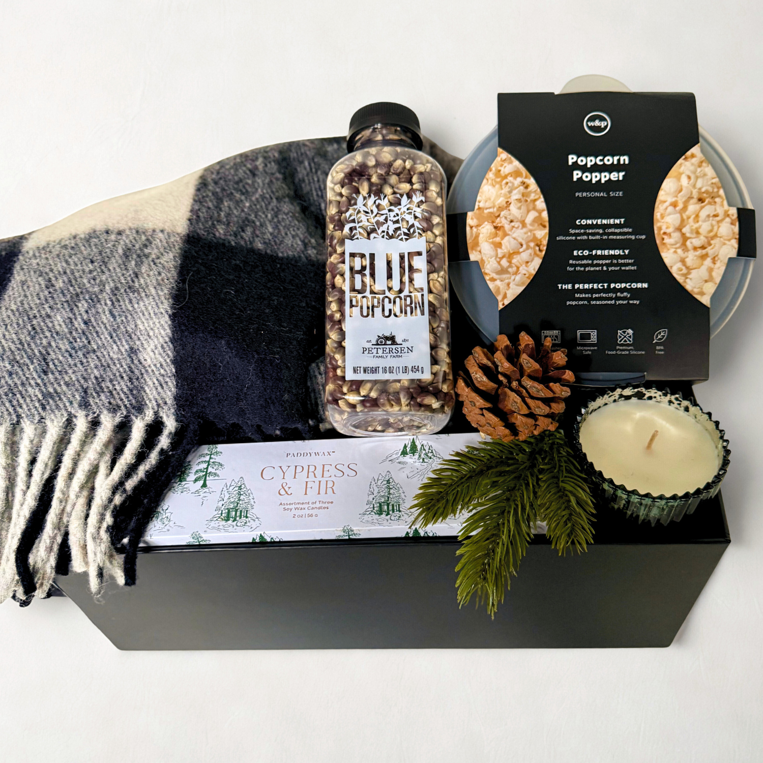 Popcorn gift set with Blue Popcorn kernals, Popcorn Popper, candles, and blanket on a white background