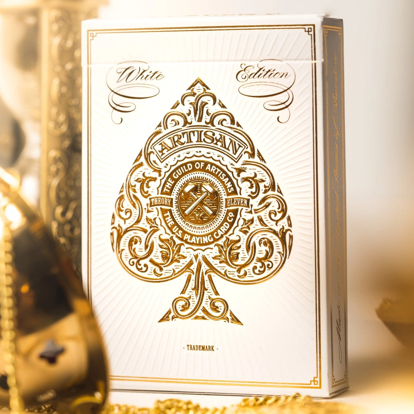 White edition playing cards with gold design on a white background