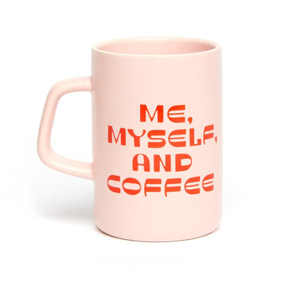 A pink ceramic mug with the text 'me, myself & coffee' printed in orange.